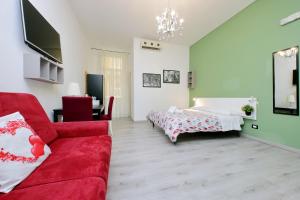 uma sala de estar com um sofá vermelho e uma cama em Lucky Holiday Rooms em Roma