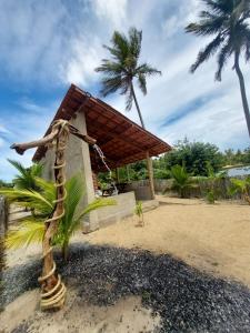 a small building on the beach with palm trees at Chalé Brisa da Lagoa in Icaraí