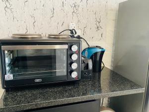a black microwave sitting on a counter with a coffee pot at Views from The 509 in Johannesburg