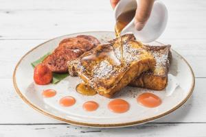 a plate of french toast with syrup on it at Sheraton Waikiki Beach Resort in Honolulu