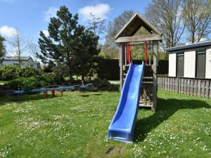 a playground with a blue slide in a yard at Cozy chalet for 5p with garden in a lovely area near Goedereede in Goedereede