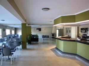 un restaurante con bar y algunas sillas y mesas en Duerming Montalvo Playa Hotel, en Montalvo