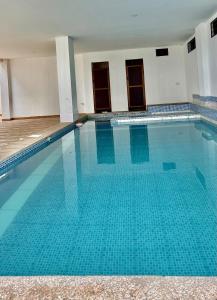 een zwembad met blauw water in een gebouw bij Apartamento Violeta con Impresionante Vista al Mar in Playas