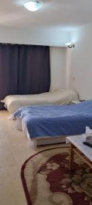 um quarto com duas camas e uma mesa com um tapete em Palma Resort em Hurghada mais 6 fotografias