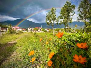 einen Regenbogen über einem Feld mit orangefarbenen Blumen in der Unterkunft Colina Haus, casa vacacional Oxa in Oxapampa