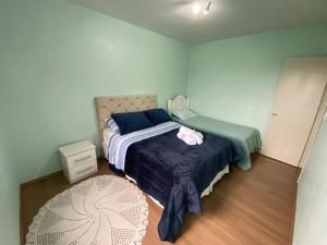 Monte Belo的住宿－Casa Temporada Monte Belo do Sul，一间卧室配有一张带蓝色棉被的床