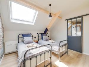 Duas camas num quarto com uma janela em Luxurious 5-star house in Limburg with jacuzzi, a paradise for families em Bree