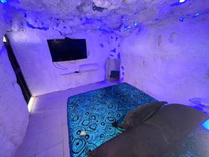 um quarto com uma cama e uma televisão numa caverna em Cabaña Parque Arvi vista panorámica em Medellín
