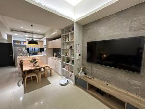 una cucina con tavolo da pranzo e una grande TV a schermo piatto di 三木三白包棟民宿 a Puli