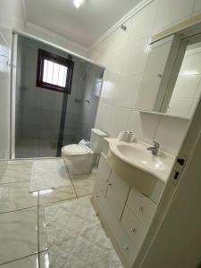 a bathroom with a sink and a shower and a toilet at Casa Temporada Monte Belo do Sul in Monte Belo