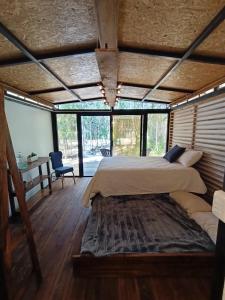 1 dormitorio con 1 cama grande en una habitación con ventanas en Zil-Kaab Hidden Glamping Village, en Tulum