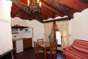 a kitchen with a table and chairs in a room at Cuevas Del Zenete in Alcudia de Guadix
