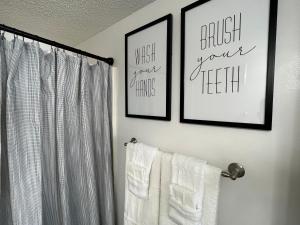 a bathroom with two pictures on the wall and towels at Condo on the Beach- walk to restaurants, shops and activities. in Gulf Shores