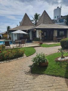 a house with a patio with tables and chairs at Flat TOP em Itaparica in Itaparica Town