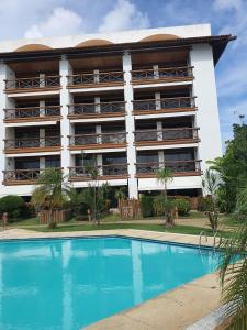 un hotel con piscina frente a un edificio en Flat TOP em Itaparica en Itaparica Town