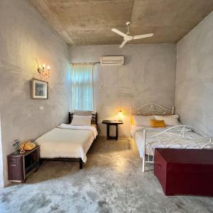 XikouにあるMIRAMONTI House 賣房間更賣生活のベッドルーム1室(ベッド2台、テーブル、シーリングファン付)