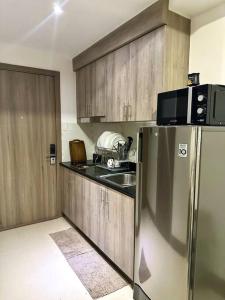 een keuken met een roestvrijstalen koelkast en een magnetron bij Modern 1-BR Condo Unit in Manilla
