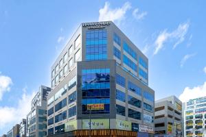 a tall building with a sign on the top of it at H-Avenue Hotel Geomdan New Town in Incheon