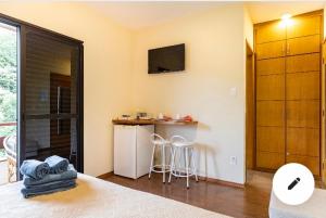 Habitación con cama y cocina con barra. en Condomínio Flat Piemonte en Serra Negra