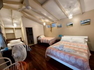 a room with two beds and a fan at Hotel M&M Beach House in Coco