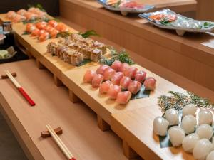 a buffet line with sushi and other food items at KAMENOI HOTEL Toba in Toba