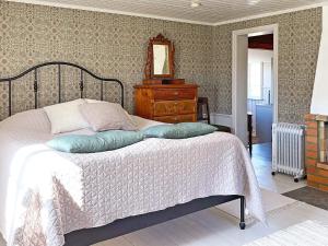 um quarto com uma cama, uma cómoda e um espelho em Holiday home MARIESTAD X em Mariestad