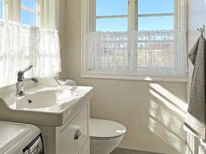 La salle de bains est pourvue d'un lavabo, de toilettes et d'une fenêtre. dans l'établissement Holiday home MARIESTAD X, à Mariestad