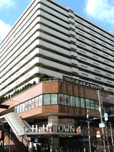 un gran edificio con un cartel encima en Wafu Ryokan Uehonmachi en Osaka