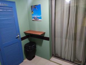 a bathroom with a shower and a blue door at La Martiniquaise in Sainte-Anne