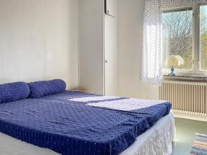 Cama azul en habitación con ventana en Holiday home Ödsmål II, en Ödsmål