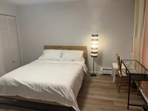 a bedroom with a white bed and a lamp at Cozy Private Home single rooms in Halifax