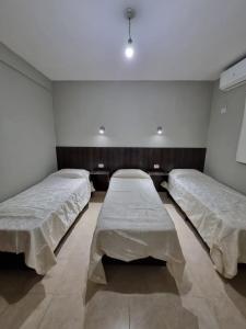 Duas camas num quarto com paredes brancas em Departamento Capital II em La Rioja