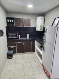 a small kitchen with a white refrigerator in it at Departamento Capital II in La Rioja