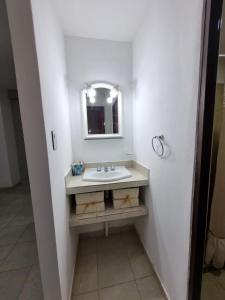 a white bathroom with a sink and a mirror at Departamento Capital II in La Rioja