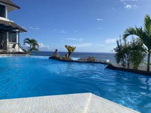 a large swimming pool with a view of the ocean at chez Karine et Robert in Punaauia