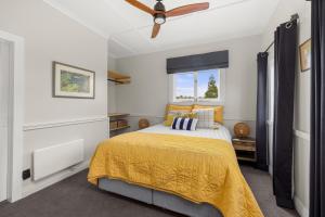 a bedroom with a bed and a ceiling fan at The Chapel- Kohukohu in Kohukohu Town District