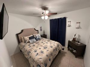 una camera da letto con un letto e un ventilatore a soffitto di 2/1 Naples Hideaway a Naples