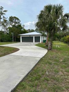 una casa con una palma accanto a un vialetto di 2/1 Naples Hideaway a Naples