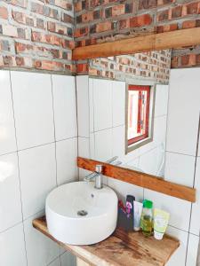 a bathroom with a sink and a brick wall at Du Già Coffee View Homestay in Làng Cac