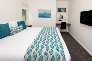 a bedroom with a large bed and a flat screen tv at BIG4 Emu Beach Holiday Park in Albany