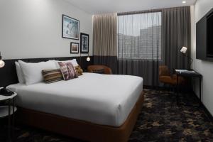 a hotel room with a large bed and a window at Rydges Fortitude Valley in Brisbane