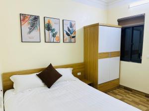 een slaapkamer met een bed en vier foto's aan de muur bij Sơn Trang House in Sa Pa