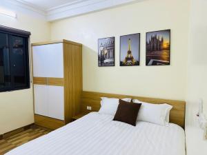 a bedroom with a bed with four pictures on the wall at Sơn Trang House in Sa Pa