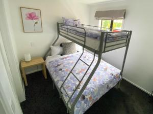 a bedroom with two bunk beds and a table at Modern 2-bedroom Apartment 7-mins walk to Queenstown in Queenstown