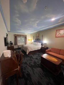 um quarto de hotel com uma cama e um sofá em Crystal Suites em Texas City
