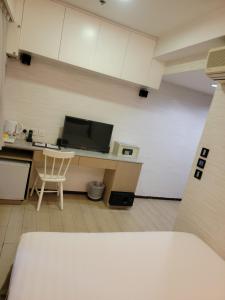 Dieses Zimmer verfügt über eine Küche mit einem Schreibtisch und einer Mikrowelle. in der Unterkunft Mingle With The Star in Hongkong