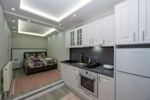 una cocina con armarios blancos y una cama en el fondo en BOSPHORUS EXCLUSİVE RESİDENCE en Estambul