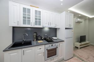 a kitchen with white cabinets and a sink and a refrigerator at BOSPHORUS EXCLUSİVE RESİDENCE in Istanbul