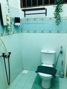 a bathroom with a toilet with a black towel at The Beach House @ Kuantan in Kuantan