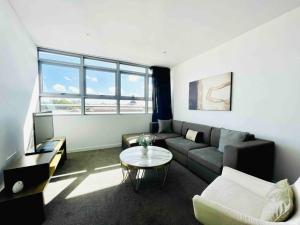 uma sala de estar com um sofá e uma mesa em Sydney Executive Apartment 3beds2baths parking Chatswood em Sydney